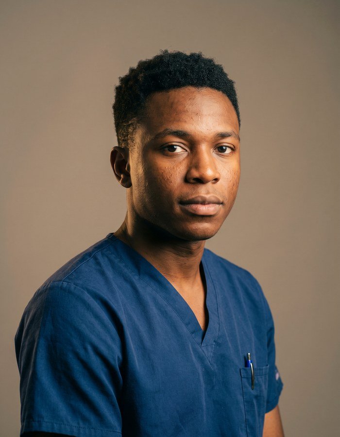 Portrait of a man in blue scrubs with his arms folded